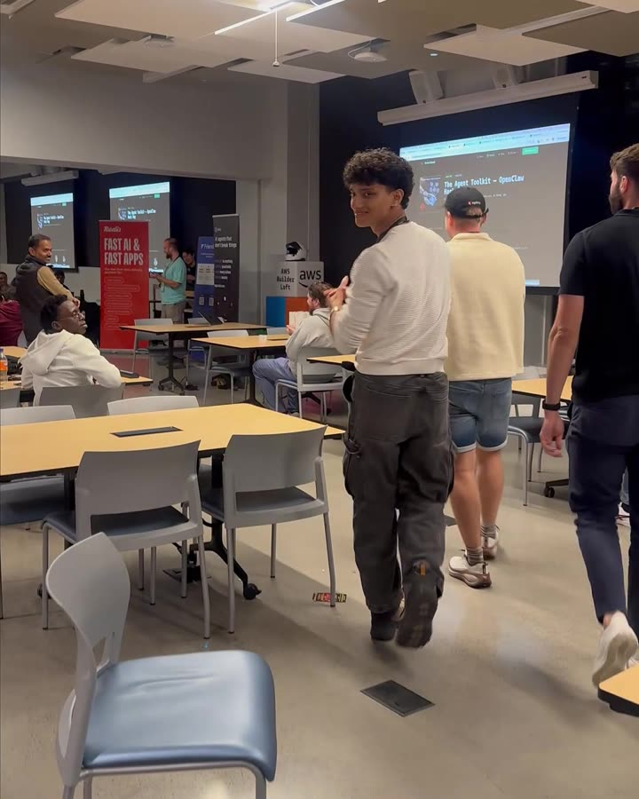 Deon smiling back at the camera as he walks up to collect the win at the AWS Builder Loft